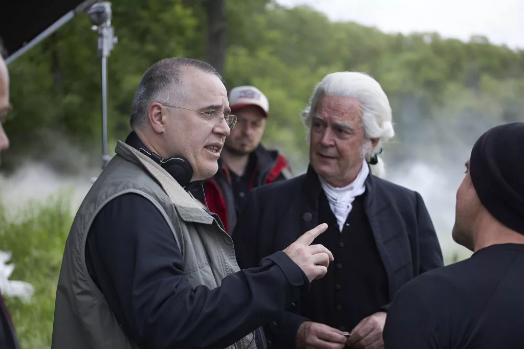 Regizorul discutând cu actorul principal în costum de epocă, making of First Bank