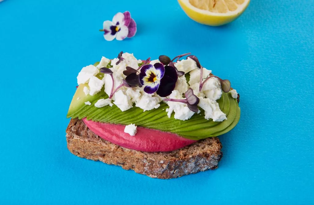 Tartină cu avocado, sfeclă și brânză pe fundal albastru — Avocadoo