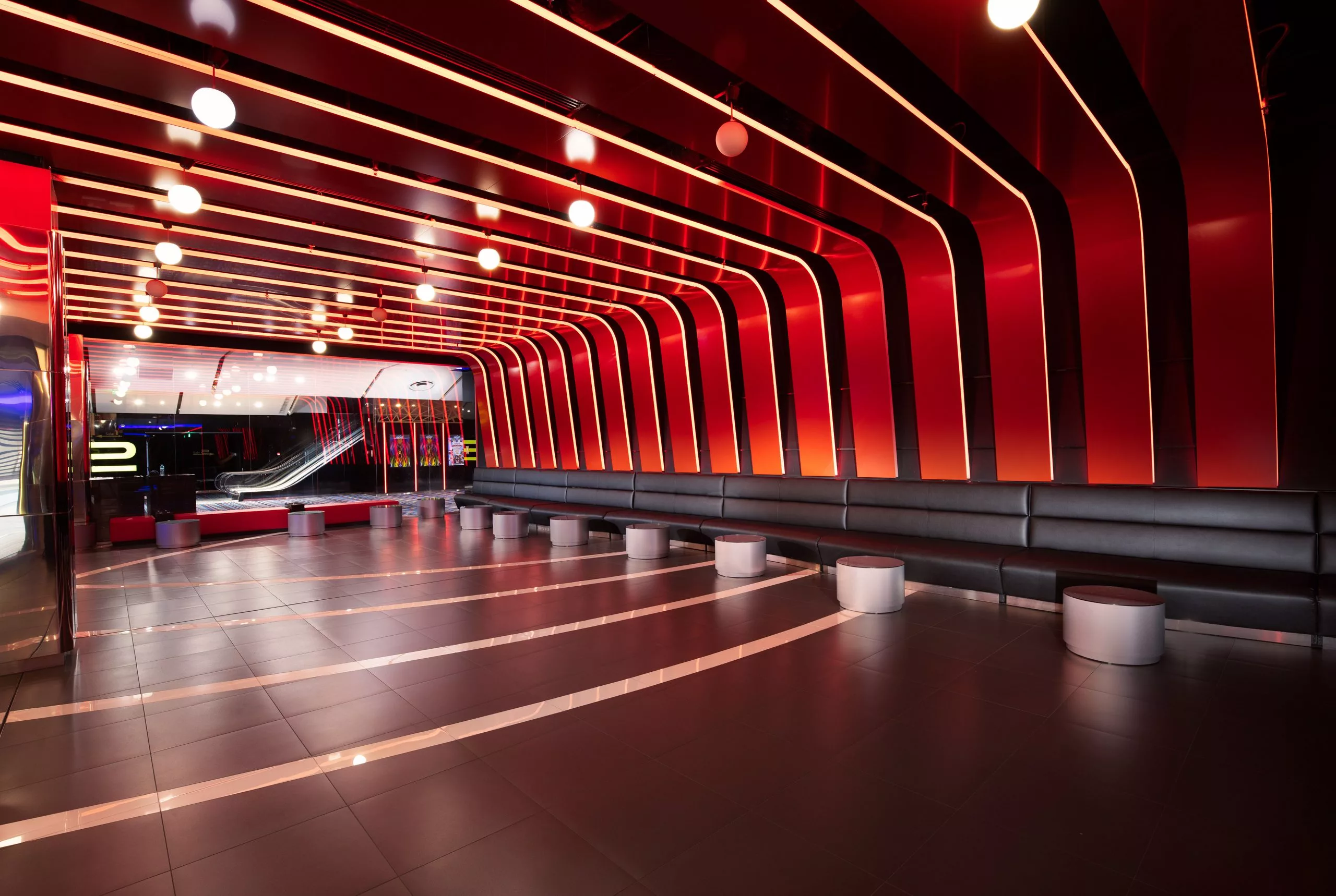 Hol curbat cu nervuri roșii iluminate, cinematograful Cineplex