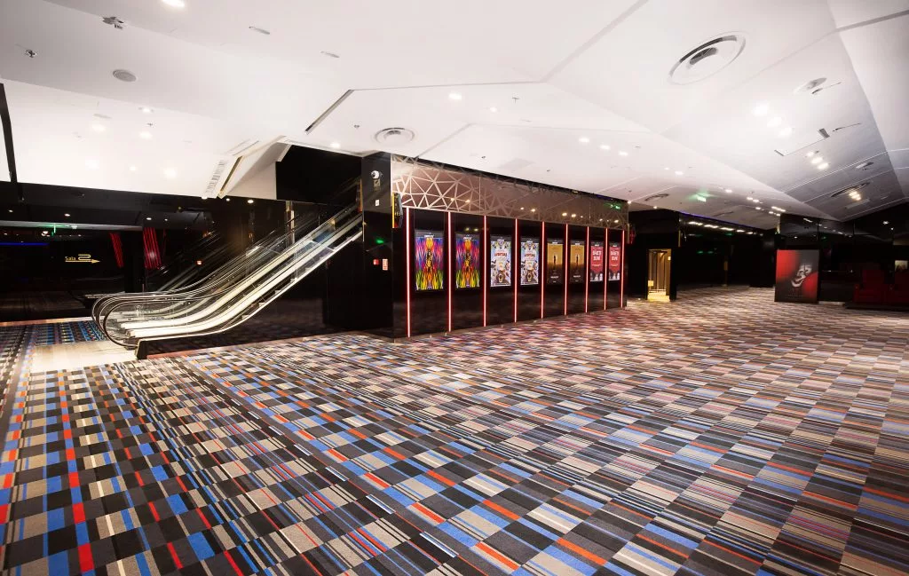 Scară rulantă și hol cu afișe în cinematograful Cineplex