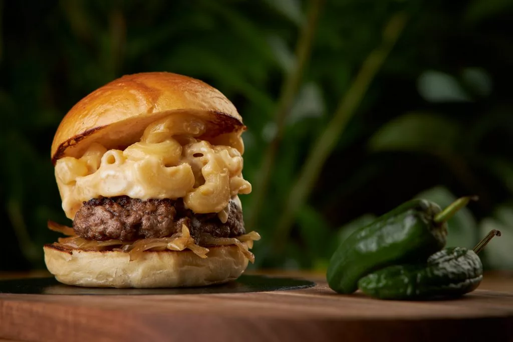 Burger cu mac and cheese pe scândură de lemn, restaurant Melt