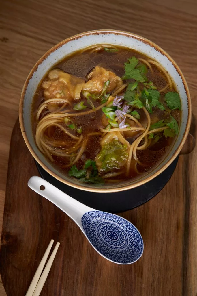 Supă cu tăiței și tofu, servită cu lingură asiatică — restaurant Melt