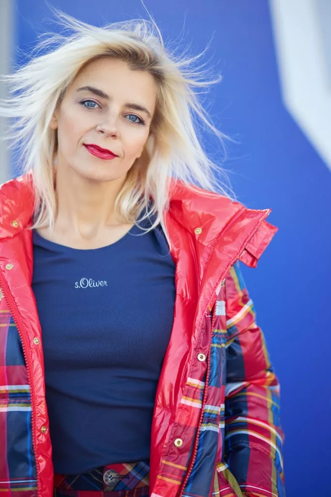 Model blond în geacă roșie peste cămașă în carouri, campanie s.Oliver