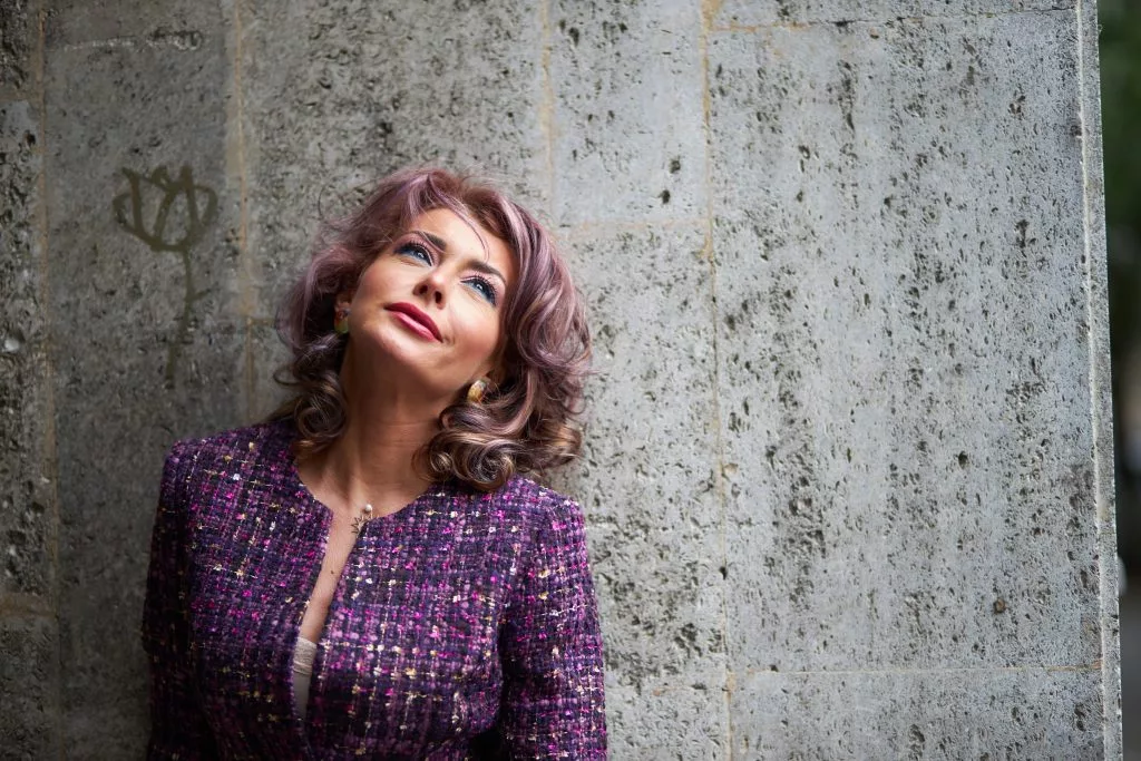 Portret de model YOKKO în jachetă de tweed mov, pe fundal de beton