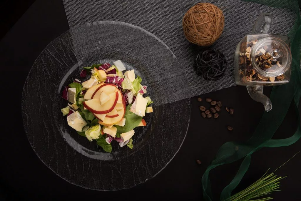 Salată cu mere în farfurie neagră, pe fundal de ardezie — The Gallery