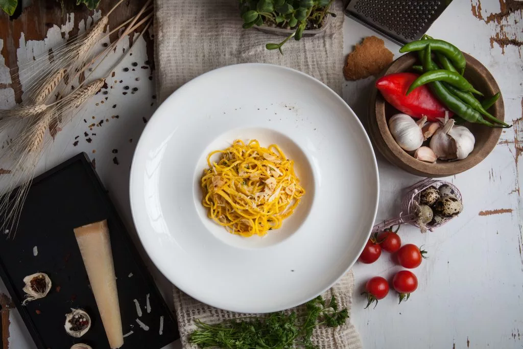 Paste în farfurie albă, înconjurate de ingrediente — The Gallery