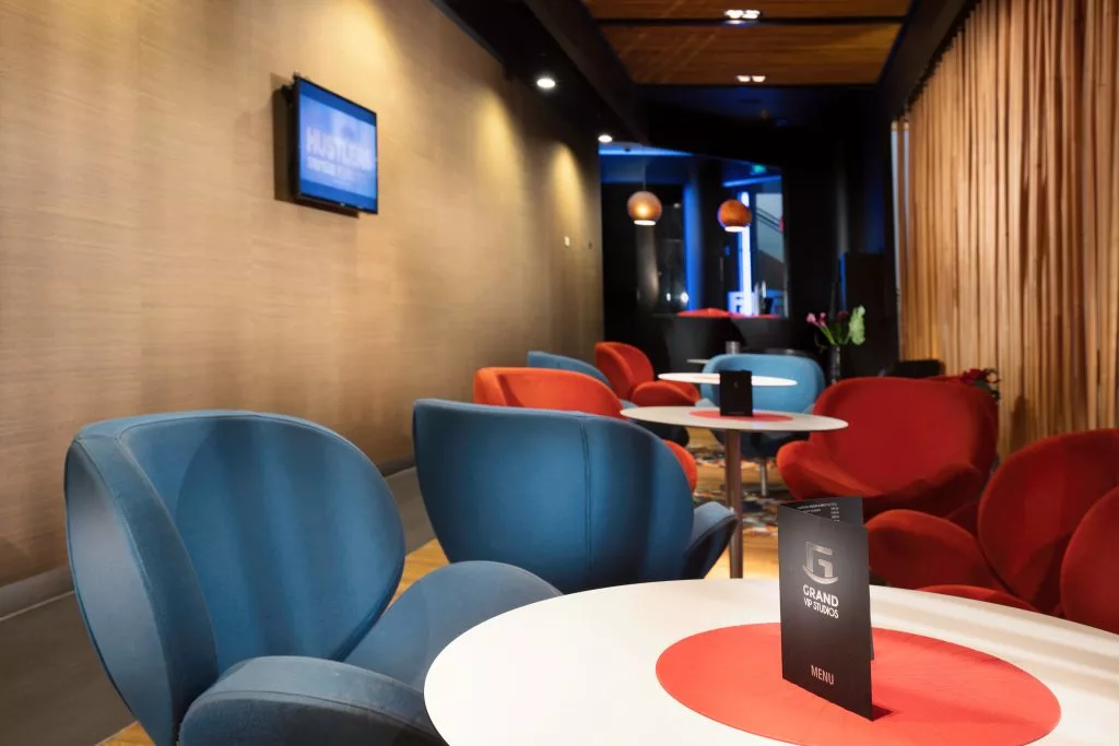 Zonă de așteptare cu fotolii și măsuțe rotunde în Băneasa VIP Studio