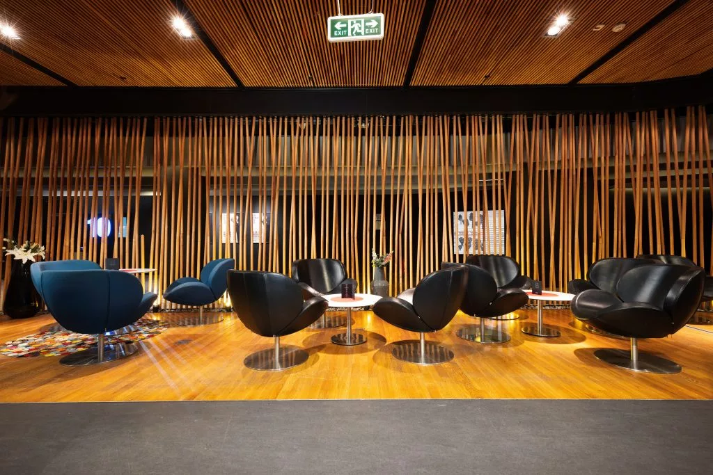 Lounge-ul Băneasa VIP Studio văzut în cadru larg, cu fotolii negre și albastre