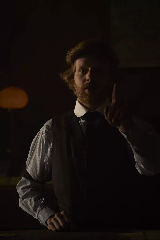 Actor tânăr în costum de epocă, luminat de lumânare — cadru din reclama First Bank