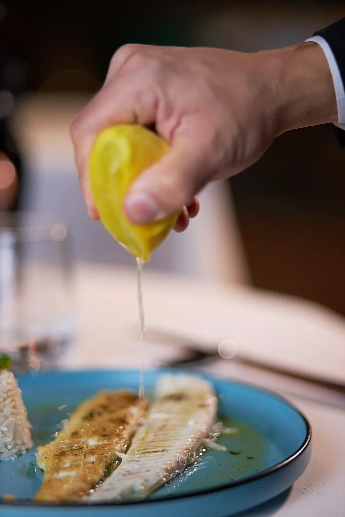 Mână stoarcând lămâie peste un file de pește, Restaurant Stejarii