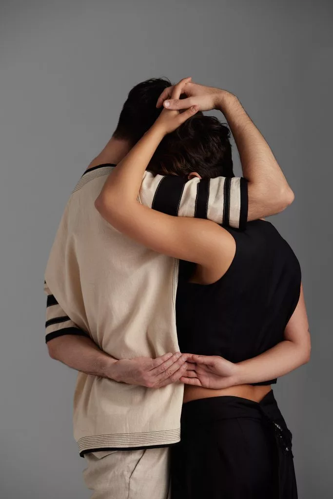 Doi modele îmbrățișați din spate, în bej și negru — editorial Fashion Premium Magazine