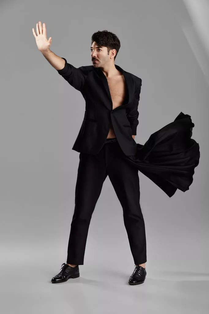 Model în costum negru, cu materialul fluturând — editorial Fashion Premium Magazine
