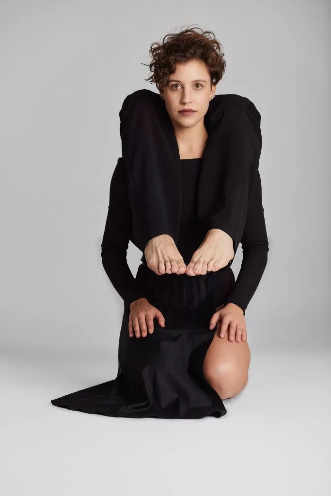 Model așezat, în sacou cu umeri structurați — editorial Fashion Premium Magazine