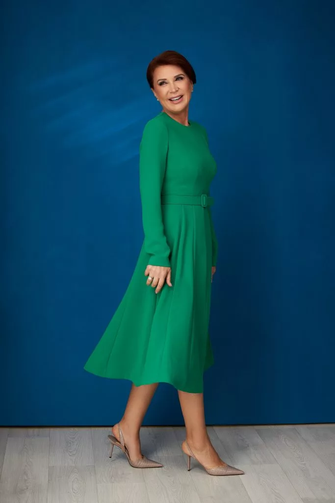 Nicoleta Radu în rochie verde, portret pe fundal albastru